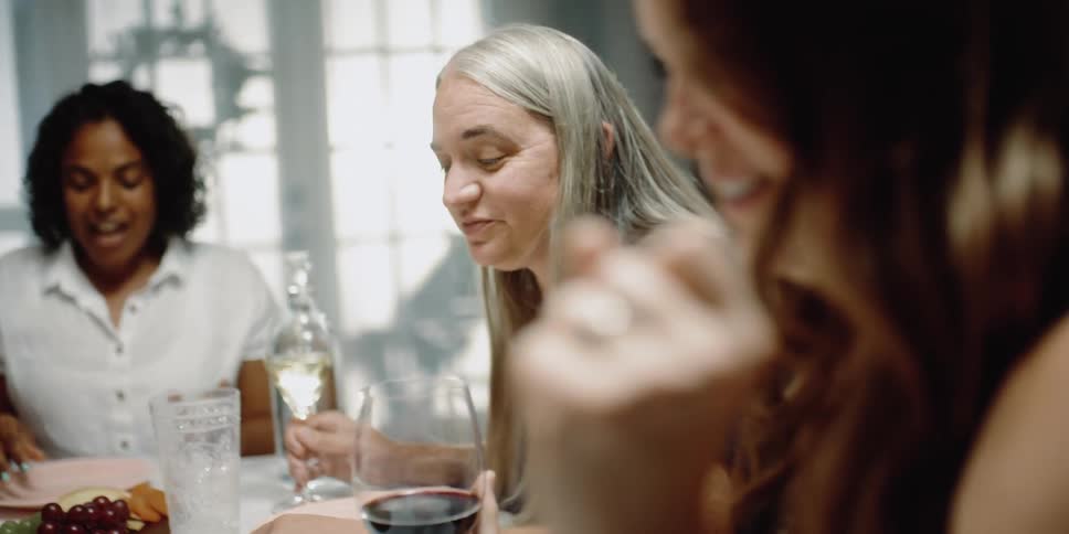 A group of friends are sitting at a table together and eating