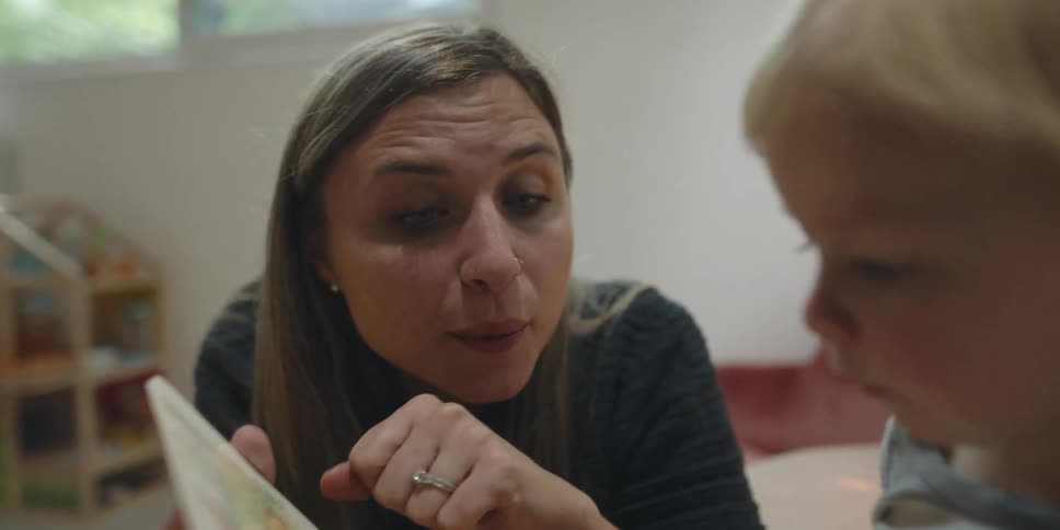 A mother is reading a book to her son