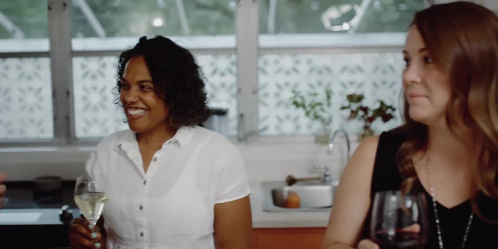 Three friends are drinking wine together and talking