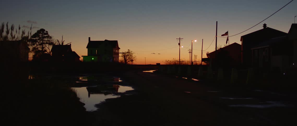 A flag waves at sunset above a flooded street
