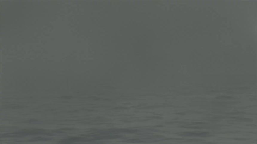 A motor boat disappears in a bank of fog