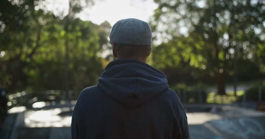 A man stands and looks out over a park