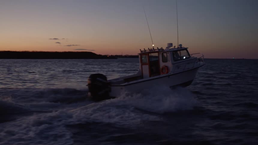 A motor boat accelerating into the sunset