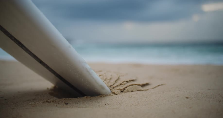 Surf board stuck in the sand on a beach
