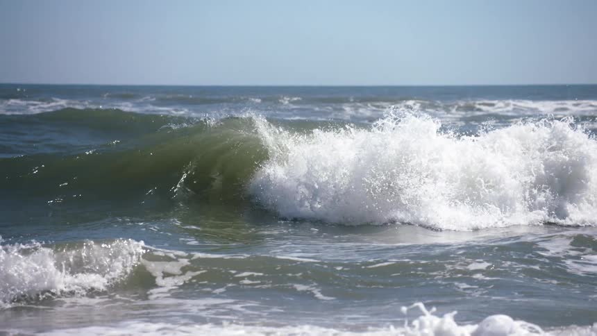 Waves splashing and rolling in on a clear day