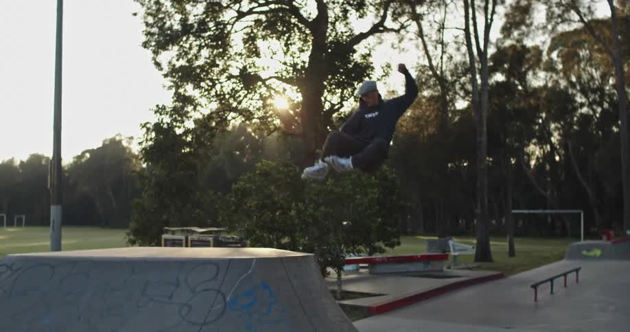 A man is skateboarding at a public park in spring