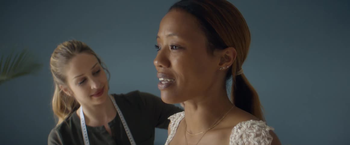 Two women are standing in a room and talking together