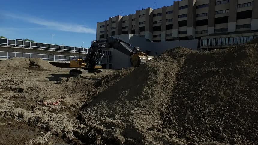 A large crane digs into the dirt