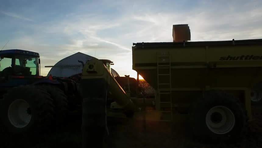 Farm equipment doing its work at sunset