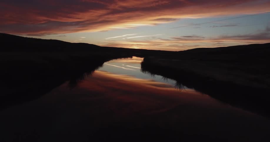 A calm river and it's banks at dawn