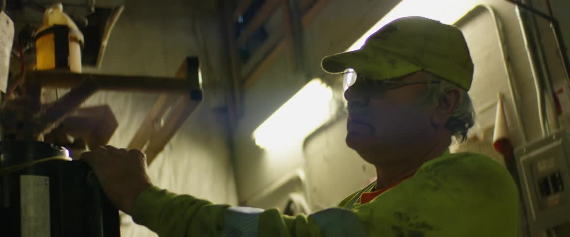 A man is working in a building and wearing a hat