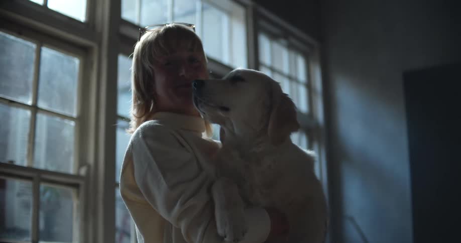A woman holding her dog and smiling