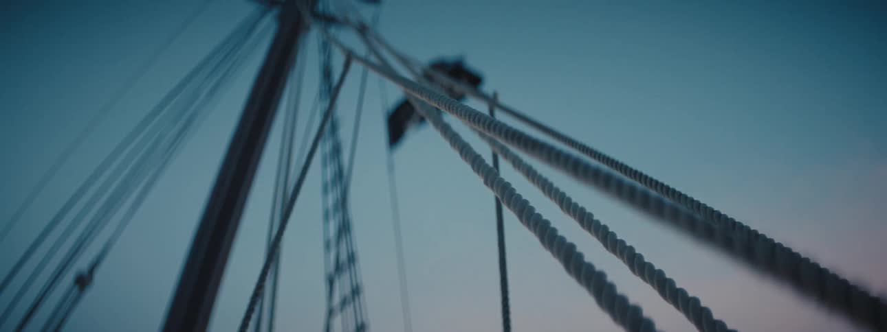 A boat is on the ocean water at dusk