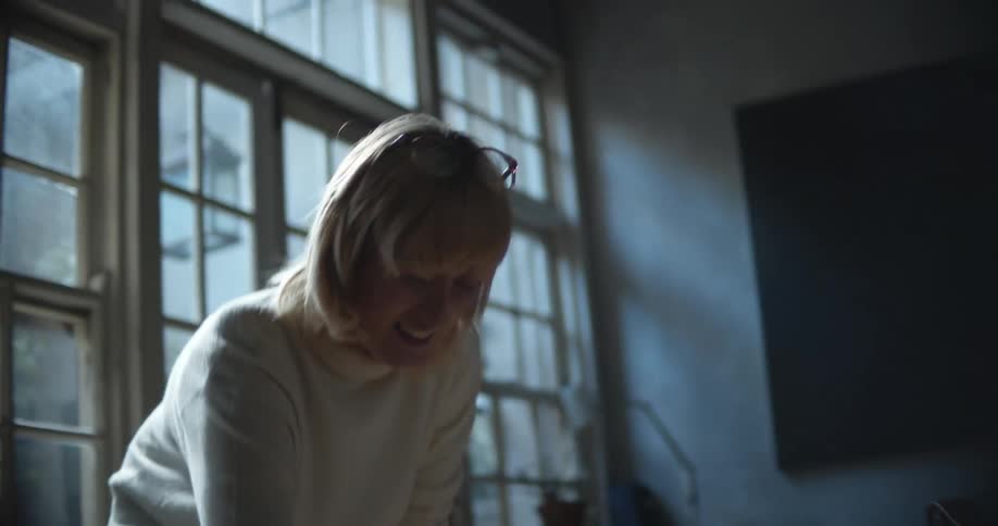 A woman is playing with her dog indoors