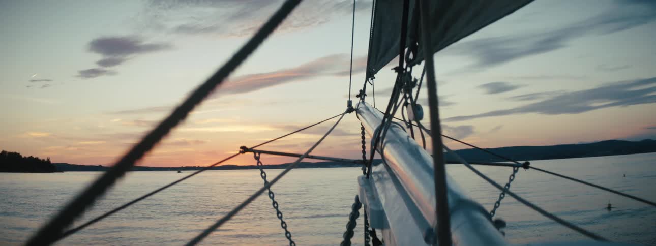 The water in front of a sailing boat as the sun sets