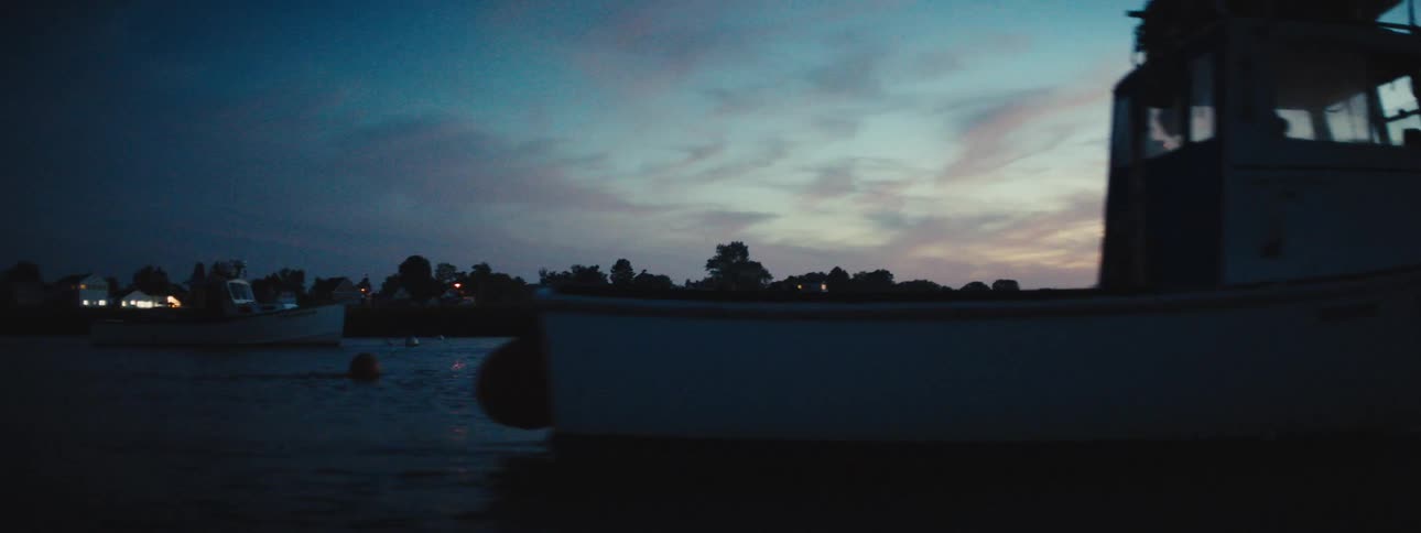 Small boats out in the ocean in the evening time