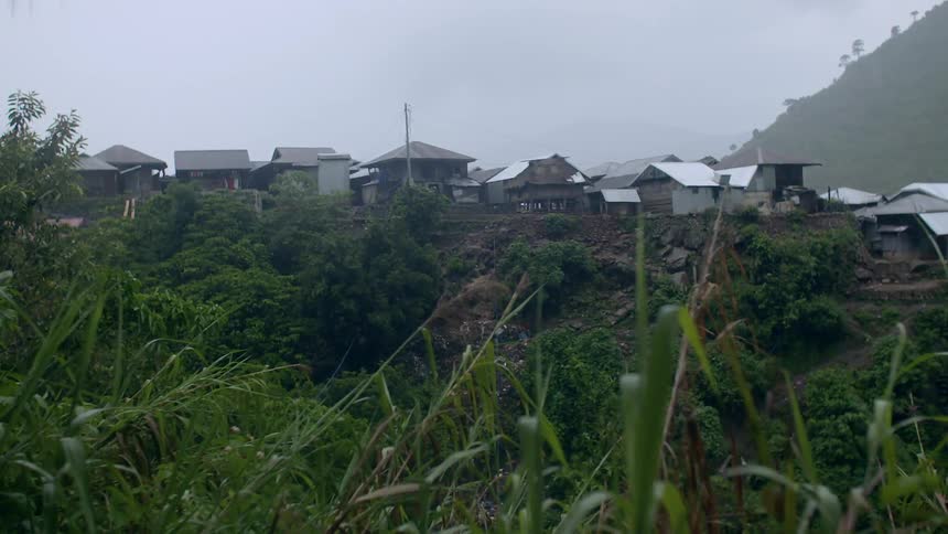Rain falling over a small village in the distance