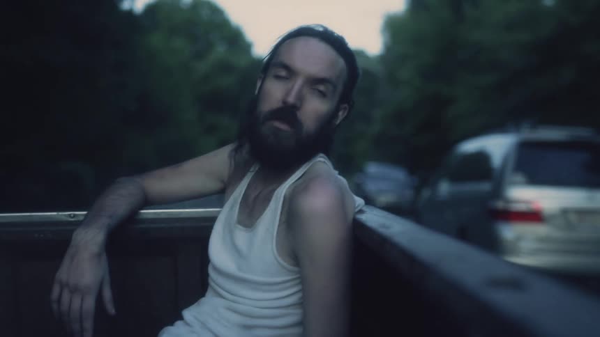 A man is riding in the back of a pickup truck