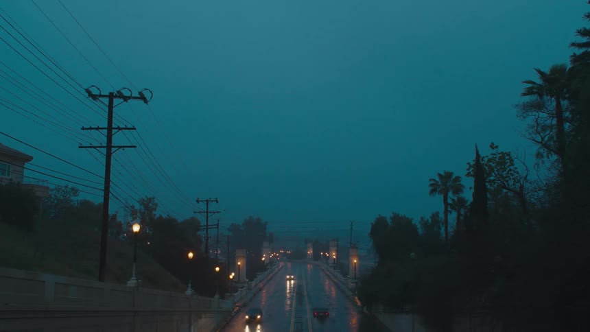 Cars driving down a wet city road
