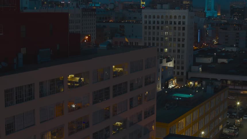 Apartment buildings and vehicle headlights light up a city at night
