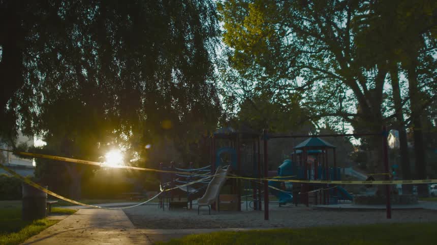 A playground surrounded by warning tape in the evening
