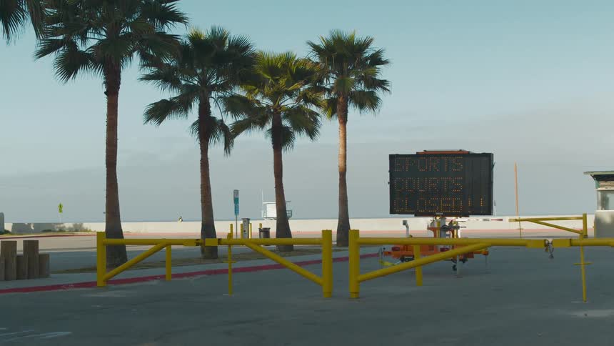 The beach is closed with barriers and a large sign