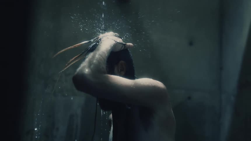 A man is bathing in water dripping down