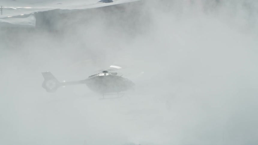 A helicopter landing at a snowy ski resort in winter