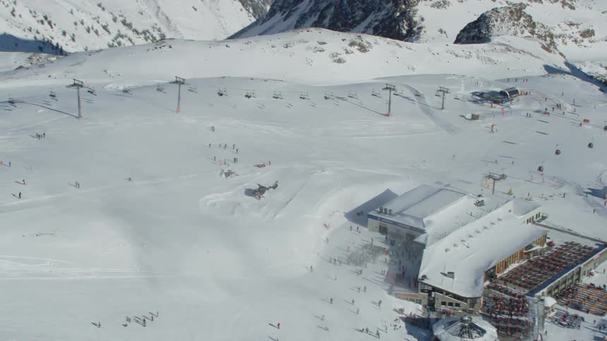 Skiers ride lifts and walk toward their busy resort