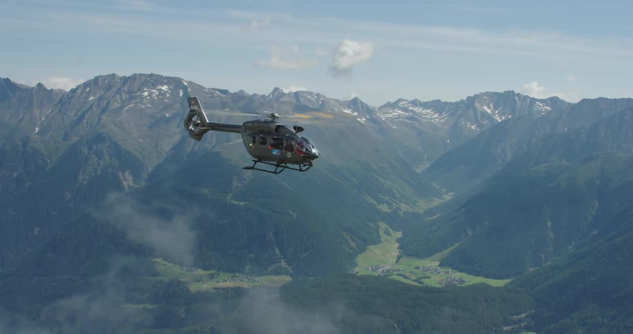 A helicopter flying over a mountain range