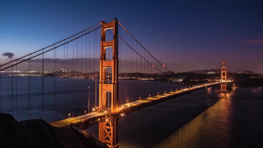 Time lapse of vehicles driving over a bridge at dawn