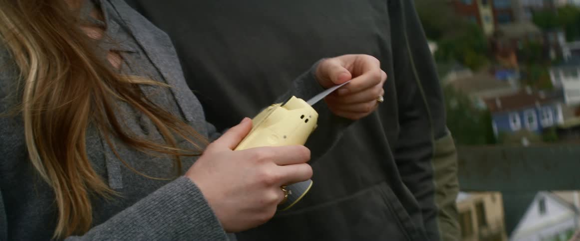 A woman pulls a photograph from a camera