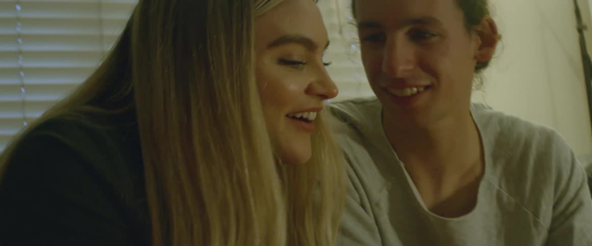 A man and a woman smiling and looking at pictures
