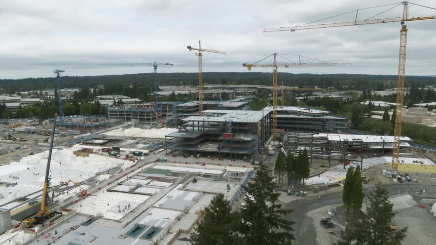 Multiple tower cranes work above a new office park complex under construction