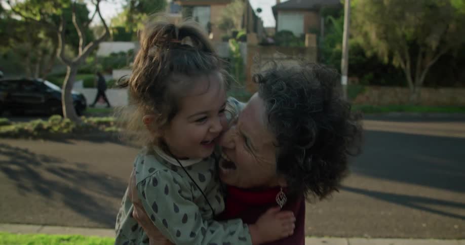 A grandmother holding her granddaughter outdoors