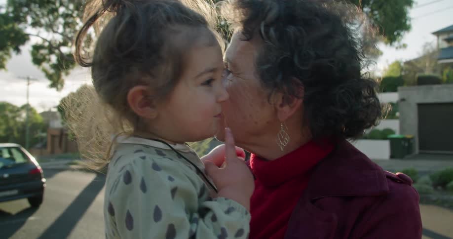 A grandmother is holding her granddaughter