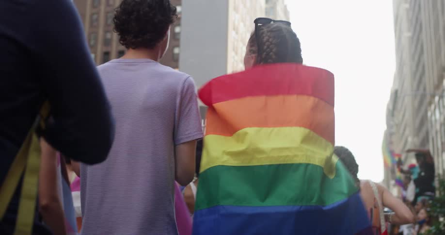 A crowd of people are marching at a pride festival