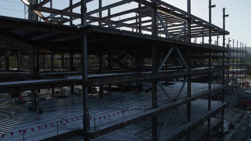 Sunshine filters between the steel columns and beams of a new office building under construction