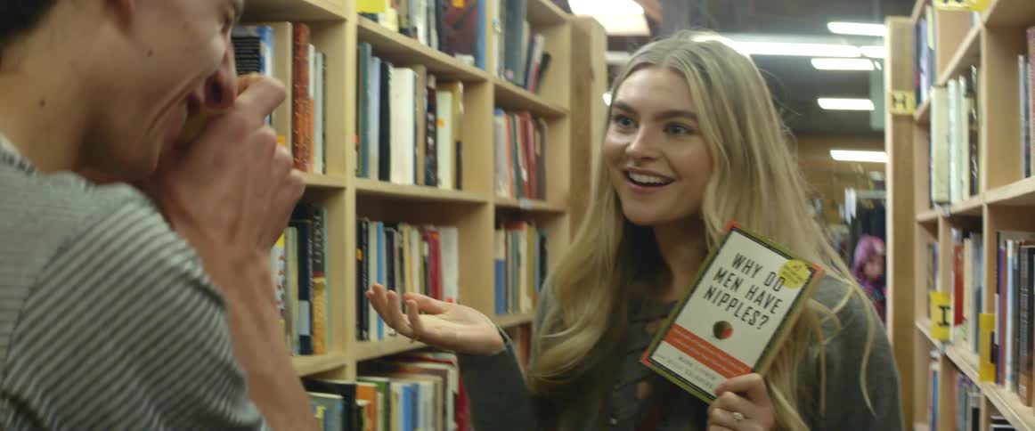 A  girl poses with a book to have her picture taken