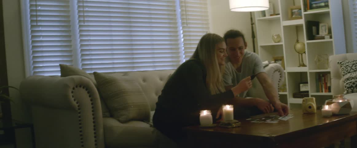 Two people look at photos while sitting on a couch