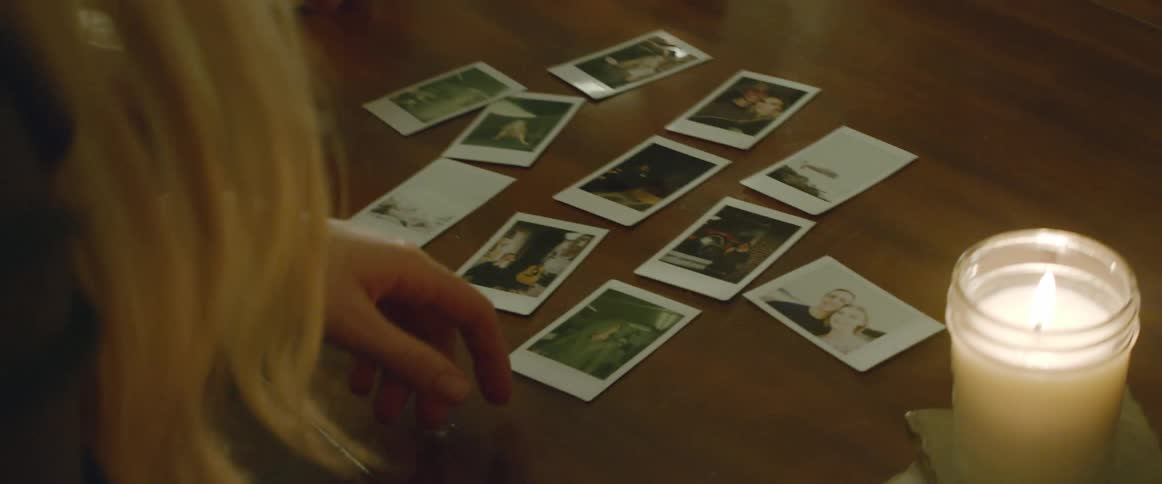 A woman is looking at photographs on a table
