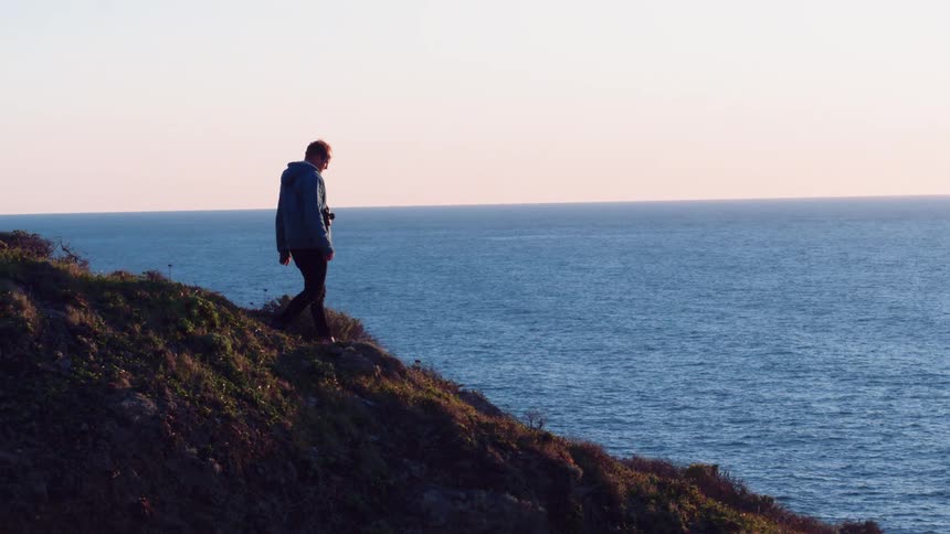 A man is walking down a mountain
