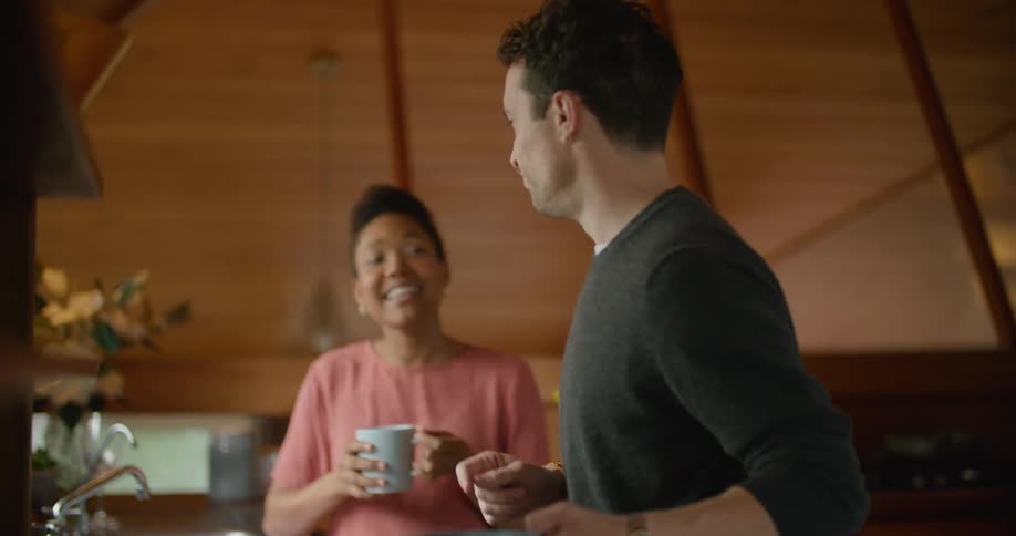 Young couple talking in the kitchen at home