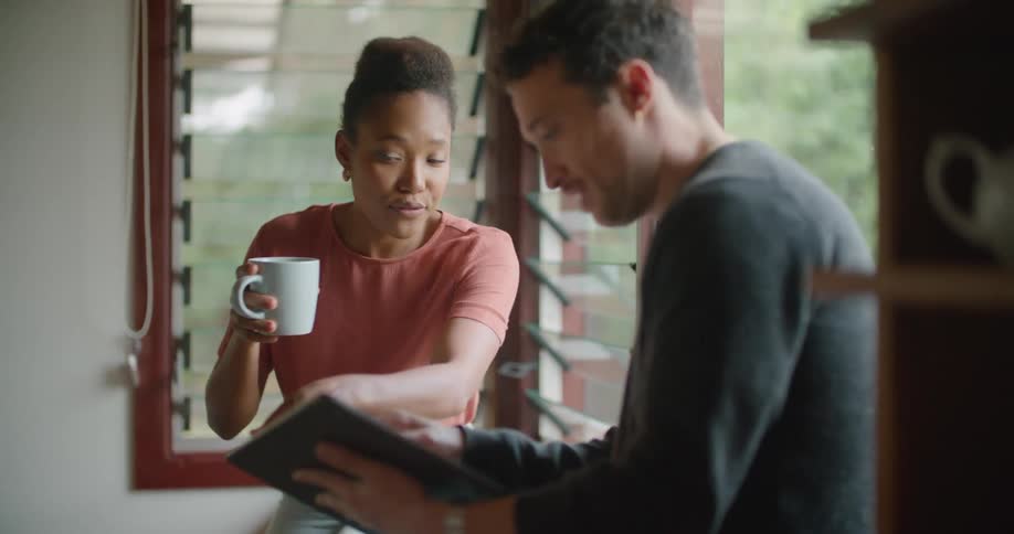 A couple drink and use a tablet at home