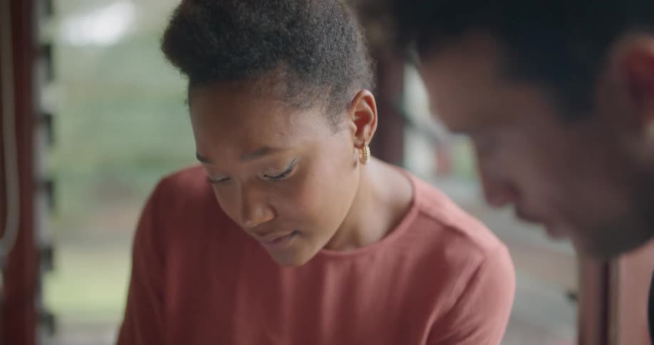 A man and woman sit at home and talk and look at a tablet