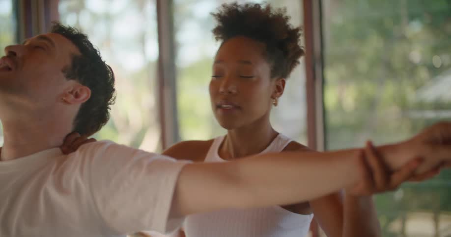 Yoga instructor guiding a student practicing at home