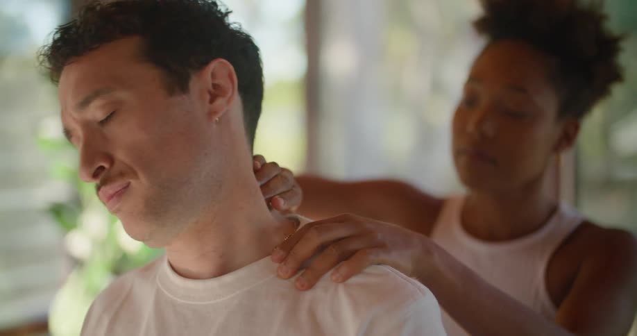 A woman is massaging a mans shoulder