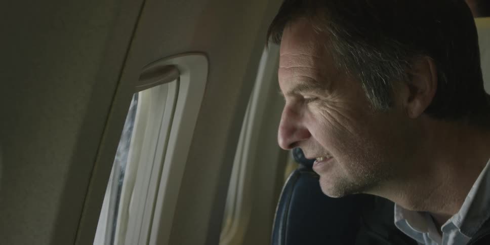A man looks out of a plane window