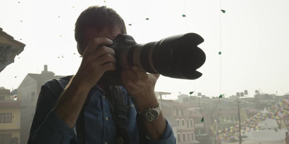 A photographer yielding a large camera lens snaps a photo