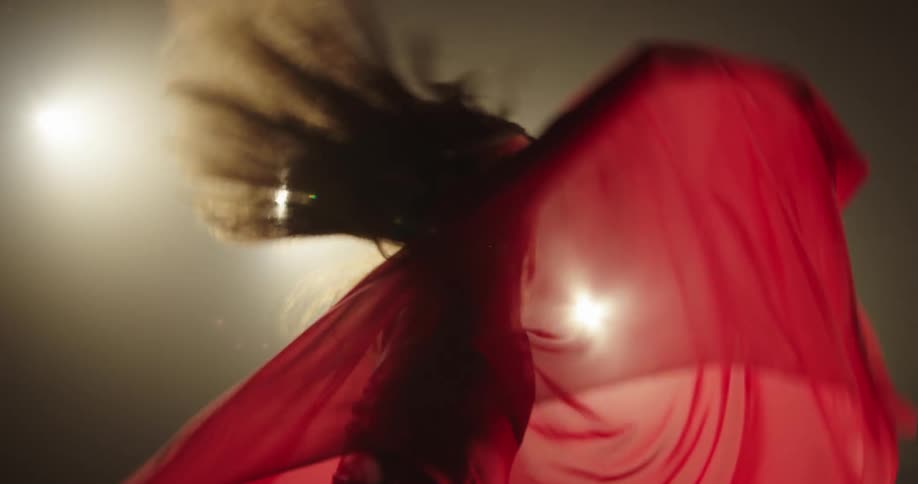 A woman in a red dress twirls around as she dances